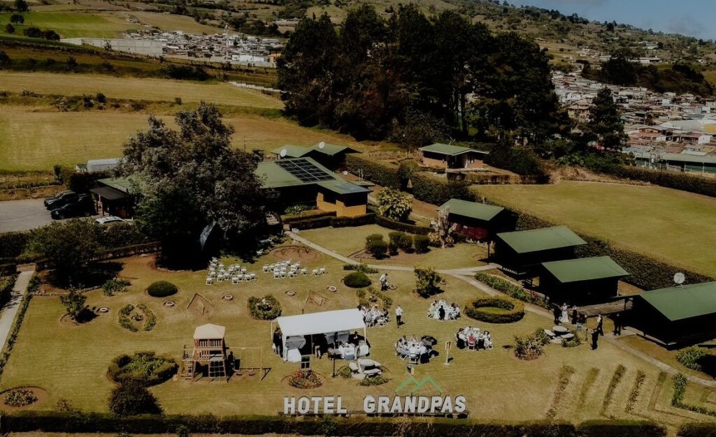 Vista aérea de las salas de eventos al aire libre en el Hotel Grandpas con jardines y carpas.